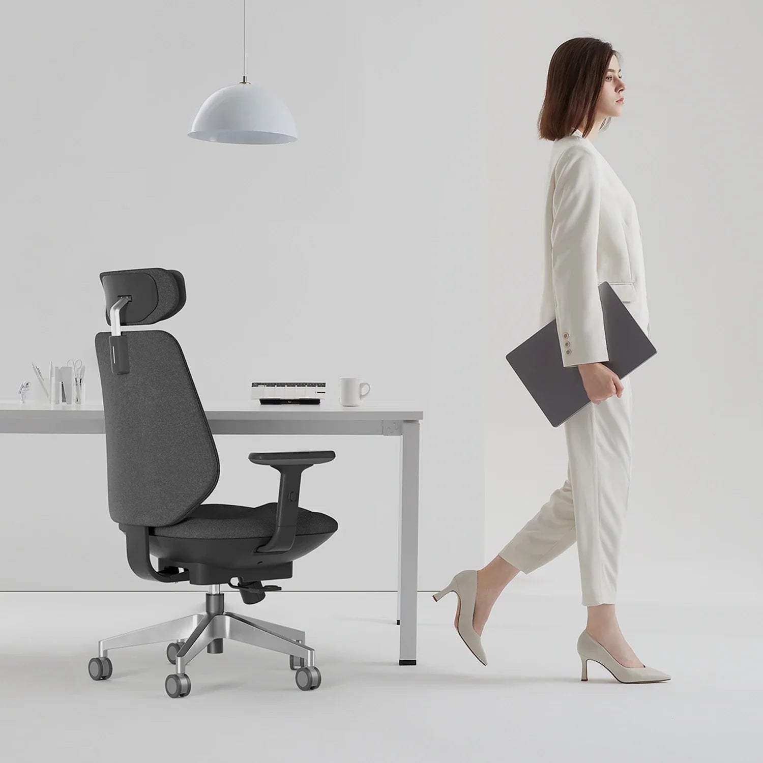 [scene] Woman using Air-Smart chair at standing desk in bright home office.